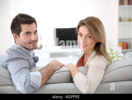 Couple sitting relaxing in sofa at home Stock Photo