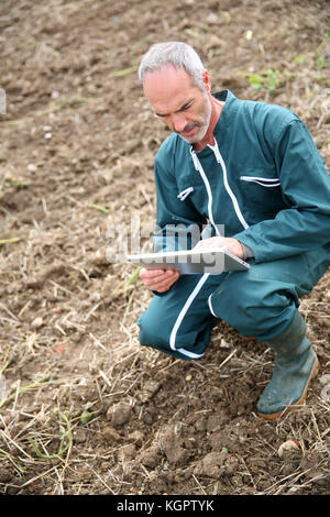 Farmer in field using digital tablet Stock Photo