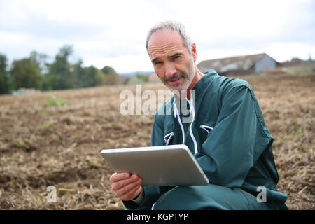 Farmer in field using digital tablet Stock Photo