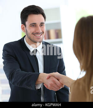 Woman giving handshake to financial adviser Stock Photo