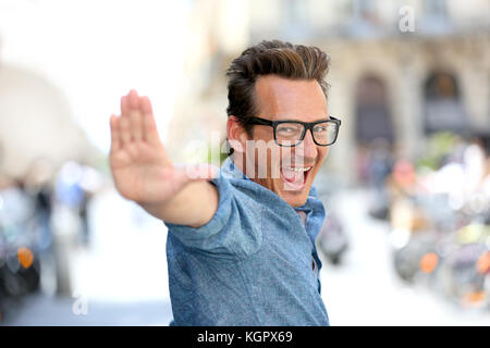 Cheerful guy with eyeglasses pointing at camera Stock Photo