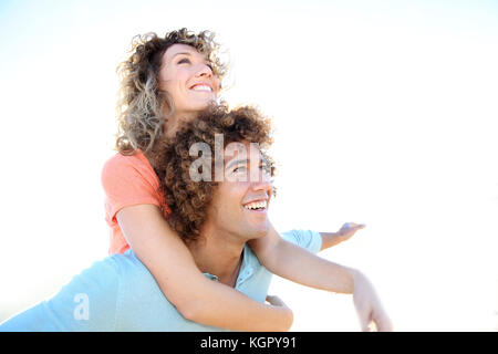 Man giving piggyback ride to girlfriend on the beach Stock Photo