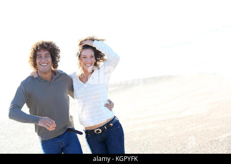 Cheerful couple running on the beach Stock Photo