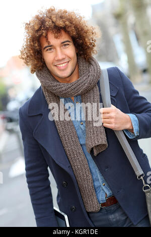 Smiling handsome guy walking in street Stock Photo
