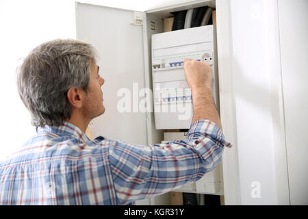 Technician checking on electric box in private home Stock Photo