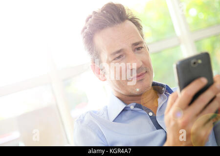 Portrait of middle-aged man using smartphone Stock Photo