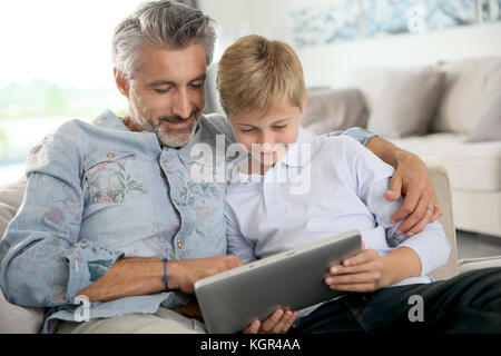 Father and son using digital tablet at home Stock Photo