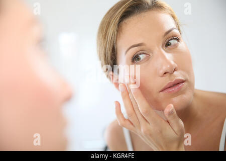 Middle-aged woman applying anti-aging cream Stock Photo