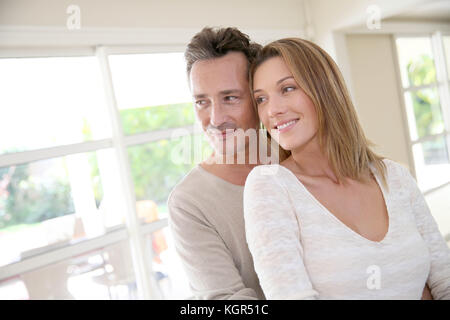 Cheerful 40-year-old couple embracing each other at home Stock Photo