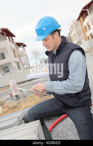 Supervisor using electronic tab on construction site Stock Photo