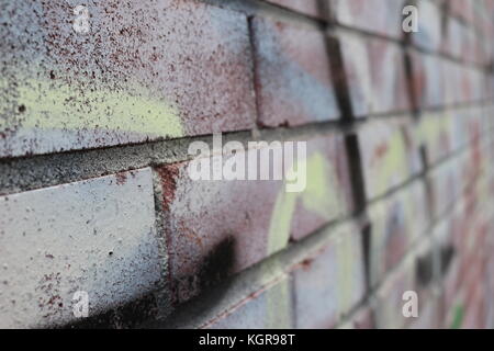 Spray paint Graffiti on Brick Wall and fence Stock Photo