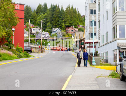 A couple seen walking down a street in Ketchikan, Alaska in a residential neighborhood. Stock Photo