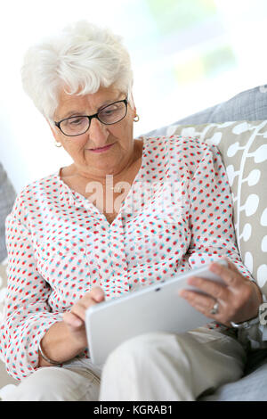 Elderly woman using digital tablet at home Stock Photo
