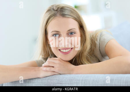 Portrait of beautiful blond woman relaxing in sofa Stock Photo