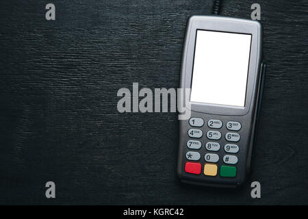 Credit card terminal on dark wooden desk Stock Photo