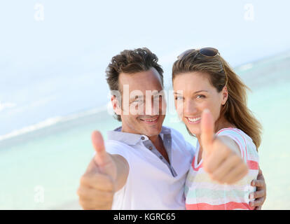 Happy couple showing thumbs up to camera Stock Photo