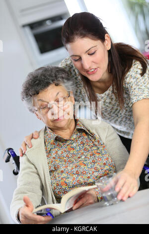 Portrait of elderly woman in wheelchair with home carer Stock Photo