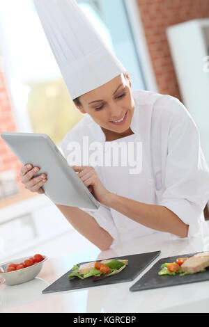 Professional cook in kichen using digital tablet Stock Photo