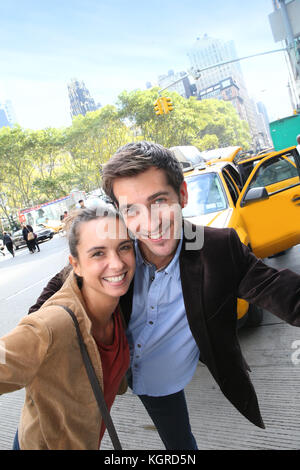 Couple having fun in Manhattan, taxi cab in background Stock Photo