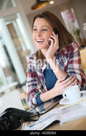 Brunette girl talking on mobile phone in coffee shop Stock Photo