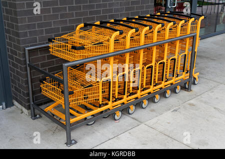 Orange metal wire shopping carts lined up outside a store in Vancouver, BC, Canada Stock Photo