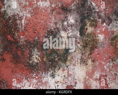 Textured background/backdrop of dark red and white patchy wall with black patches Stock Photo