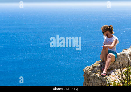 A young woman and the vast blue sea Stock Photo