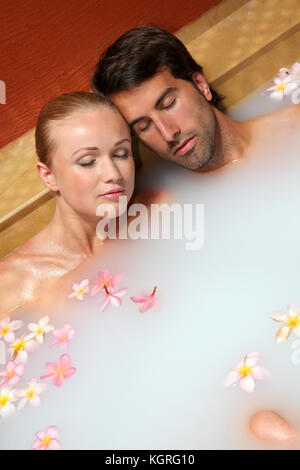 Couple relaxing in spa milk bath Stock Photo