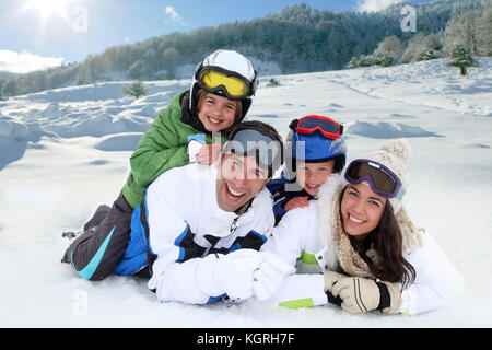 Happy family laying down in the snow Stock Photo