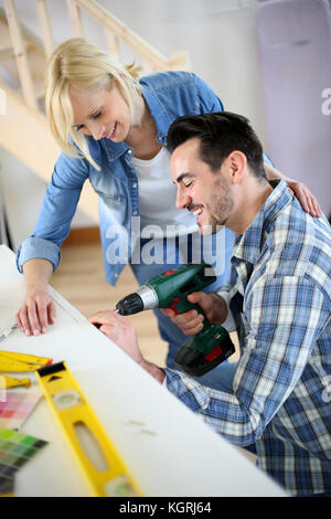 Couple installing furniture in new house Stock Photo