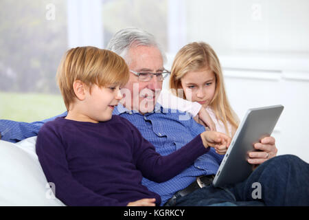 Grandfather with kids using electronic tab Stock Photo