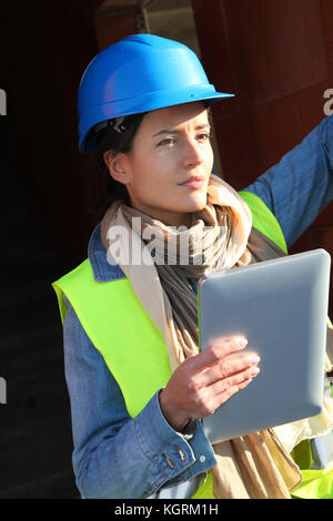 Architect on building site using electronic tablet Stock Photo