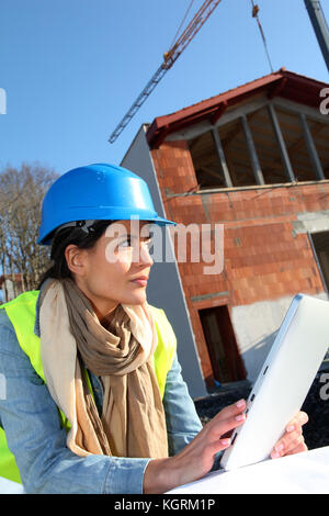 Architect on building site using electronic tablet Stock Photo
