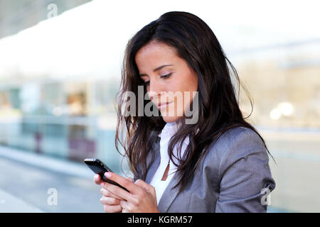 Businesswoman sending message with smartphone Stock Photo