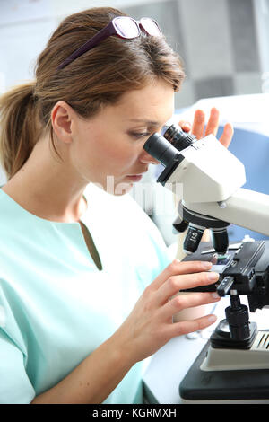Doctor in laboratory looking through microscope Stock Photo