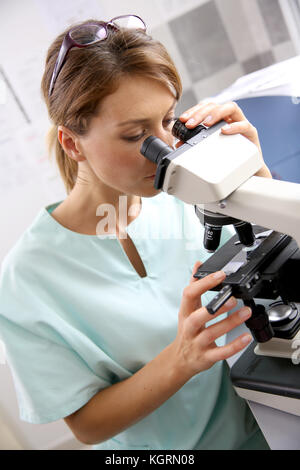 Doctor in laboratory looking through microscope Stock Photo