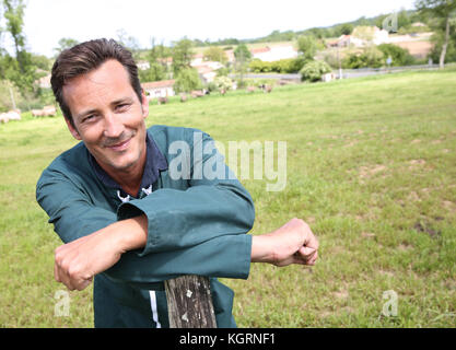 Cheerful farmer standing in country field Stock Photo