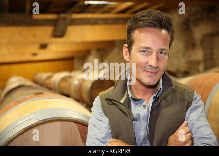 Portrait of winemaker standing in wine cellar Stock Photo