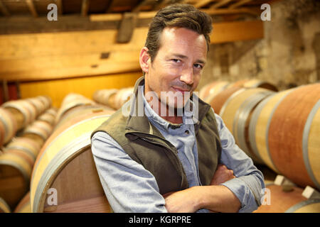 Portrait of winemaker standing in wine cellar Stock Photo