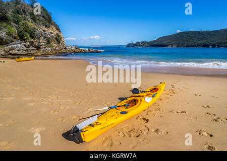 Australia, New South Wales, Central Coast, Bouddi National Park, sea kajak on the beach at Maitland Bay with view of the Bouddi Point headland Stock Photo