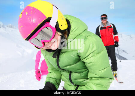 6-year-old boy skiing down ski slope with family Stock Photo