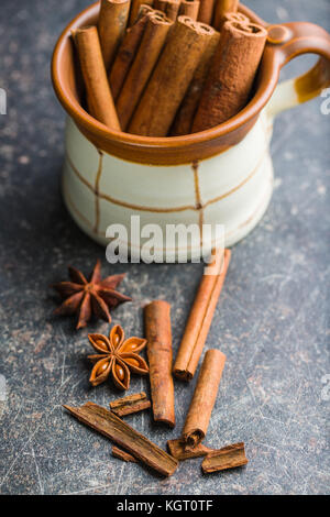 Cinnamon sticks and anise star on old kitchen table. Stock Photo