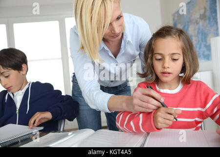 Children sitting in classroom with teacher Stock Photo