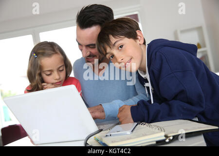 Man with children using laptop at home Stock Photo