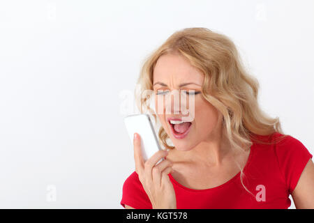 Portrait of blond woman with red shirt yelling on the phone Stock Photo