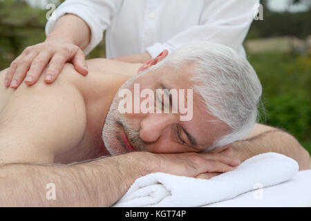 Portrait of senior man laying on a massage bed Stock Photo