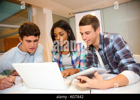 Group of students working on laptop in classroom Stock Photo