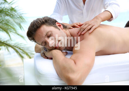 Handsome man laying on a massage bed Stock Photo