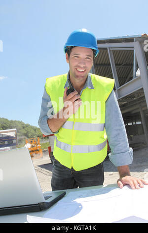 Foreman using walkie-talkie on construction site Stock Photo