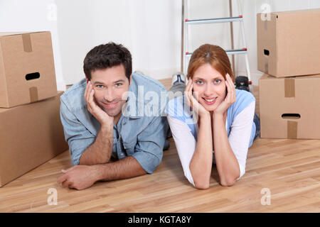 Couple laying on new house floor Stock Photo